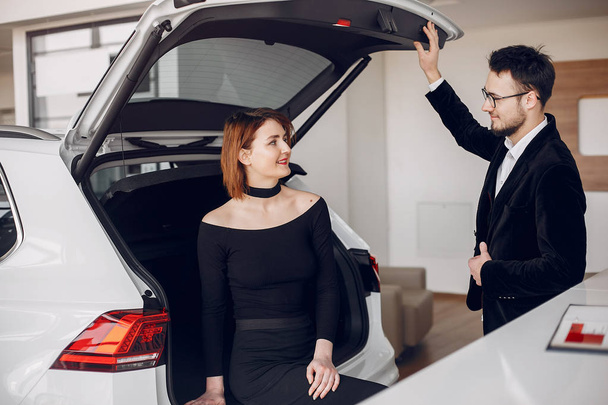 Stylish and elegant couple in a car salon - Valokuva, kuva