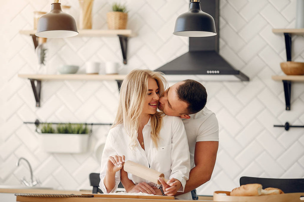 Beautiful couple prepare food in a kitchen - Foto, Imagem