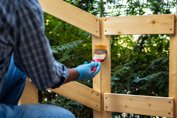 Τεχνίτης στην εργασία σε ένα ξύλινο φράχτη. - Φωτογραφία, εικόνα