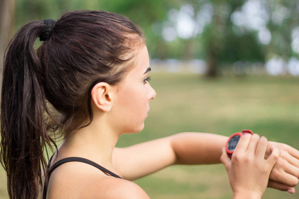 Fitness sport meisje vrouw controleert timer tijdens training training  - Foto, afbeelding