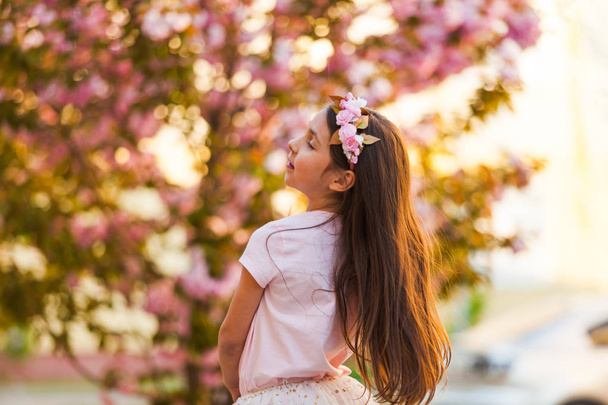 Spring portrait, adorable little girl dance near sakura tree - Foto, Imagem