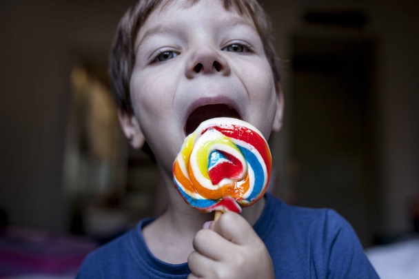 4 years old child boy licking a colorful big lollipop - Photo, Image