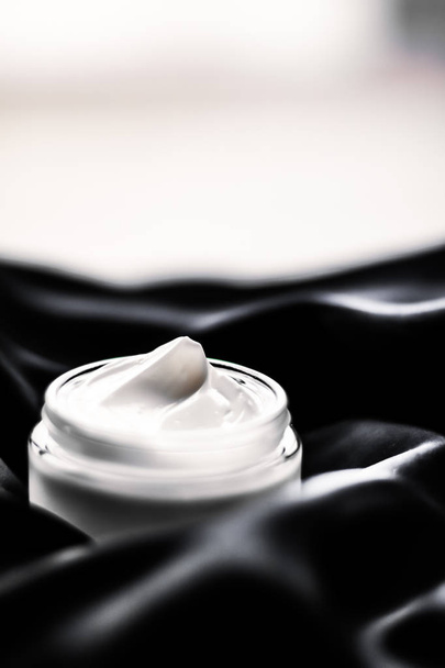 Luxe gevoelige huidverzorging hydraterende gezichtscrème op zwarte zijde  - Foto, afbeelding