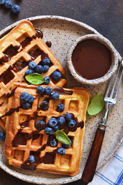 Belgian waffles for breakfast with chocolate sauce and blueberri - Фото, изображение