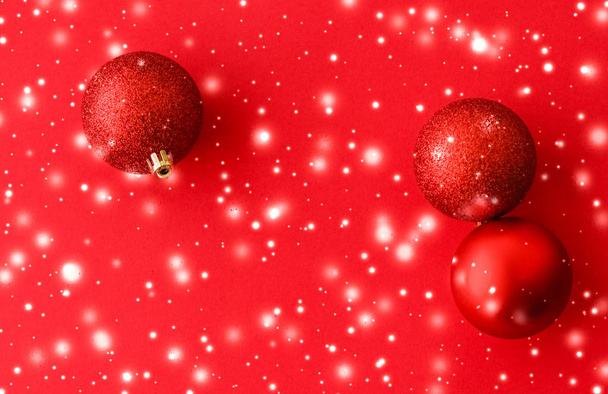 Christbaumkugeln auf rotem Hintergrund mit Schneeglitzern, Luxus - Foto, Bild