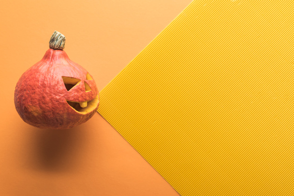 vista superior de la calabaza de Halloween tallada sobre fondo naranja y amarillo
 - Foto, Imagen