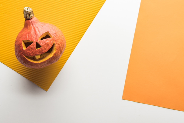 top view of Halloween pumpkin on white and orange background - Photo, Image