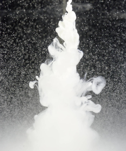weiße Flüssigkeit tropft in Wasser - Foto, Bild