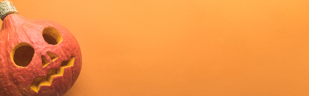 top view of spooky carved Halloween pumpkin on orange background, panoramic shot - Photo, Image