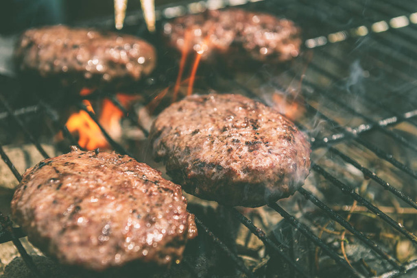 Burgers are cooking on grill with open flames - Foto, Imagem