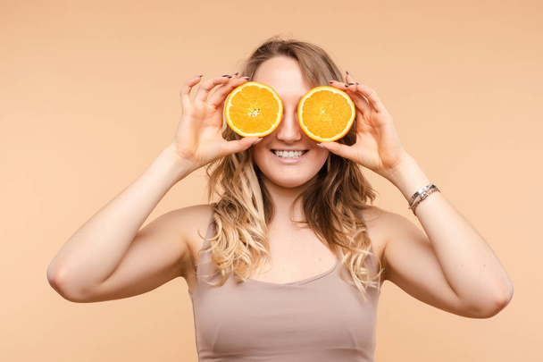 Jovem loira alegre posando com laranjas frescas
 - Foto, Imagem