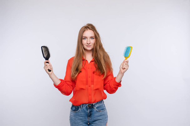 Vrouw houdt twee haarborstel poseren met een half Shaggy en gekamd haar middellange schot - Foto, afbeelding