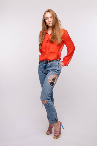 Fille en chemisier rouge et jeans posant sur fond isolé
 - Photo, image