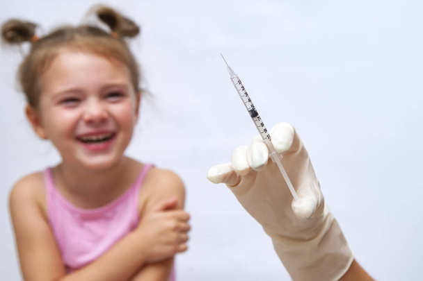 Doctor giving an injection vaccine to a girl. - Фото, зображення