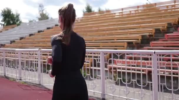 Mujer delgada corriendo en pista de carreras bajo el sol
 - Imágenes, Vídeo