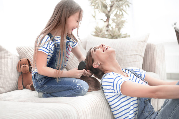 little girl combs her mothers hair - Foto, Imagen