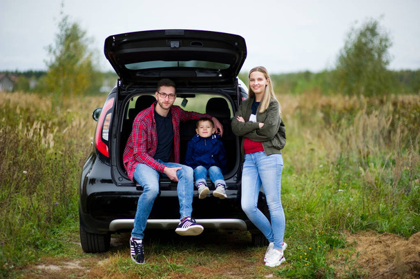 Young family with a little son on a country road with a car - Photo, Image