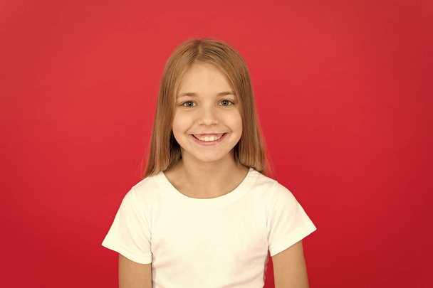 Sincere emotions. Brilliant smile concept. Girl happy smiling face over red background. Emotional kid joyful smiling face. Cheerful adorable girl smiling. Positive and optimistic. Cheerful mood - Photo, Image