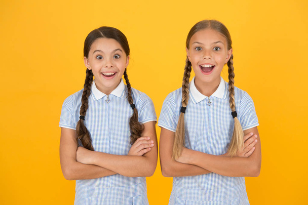 Cheerful schoolgirls yellow background. Little girls. Happy childrens day. Equal protection civil rights and freedom from discrimination. Perfect schoolgirls. Schoolgirls vintage simple style outfit - Foto, Imagem