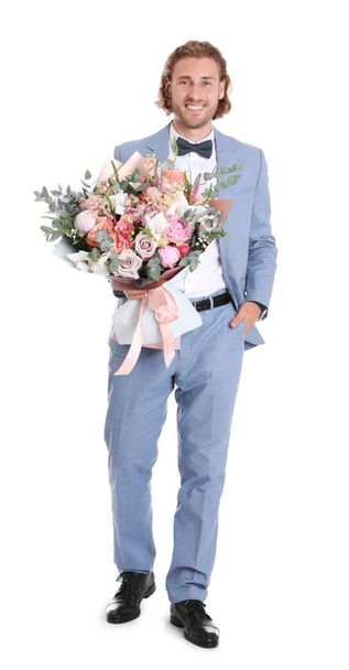 Young handsome man in stylish suit with beautiful flower bouquet on white background - Foto, Imagem