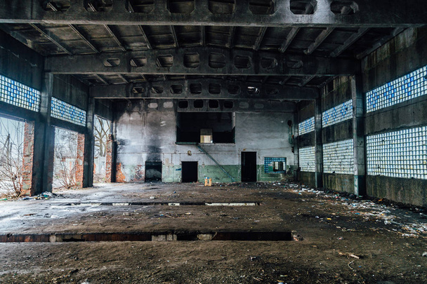 Κατεστραμμένοι εσωτερικοί χώροι του εγκαταλελειμμένου βιομηχανικού διαδρόμου. Καμένα τείχη - Φωτογραφία, εικόνα