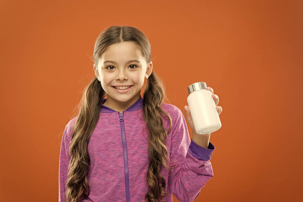 Health care. Girl long hair hold medicines bottle. Vitamin concept. Need vitamin supplements. Child cute girl take some medicines. Treatment and medicine. Natural product. Take vitamin supplements - 写真・画像
