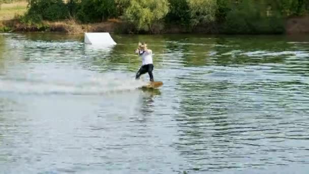 Ακραίος επιχειρηματίας με κοστούμι με γραβάτα και γυαλιά ηλίου, βόλτες σε wakeboard σε λίμνη - Πλάνα, βίντεο