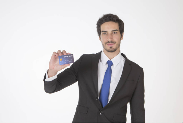 Handsome businessman, financial consultant, wearing a suit, holding a credit card, white background - Foto, immagini