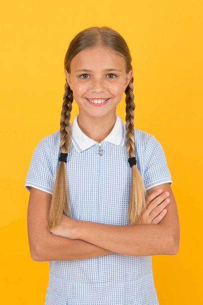 Emotional intelligence describes ability monitor your own emotions. Smiling girl. Adorable schoolgirl yellow background. Little girl. Happy childrens day. Tidy girl nice hairstyle. Positive emotions - Photo, image