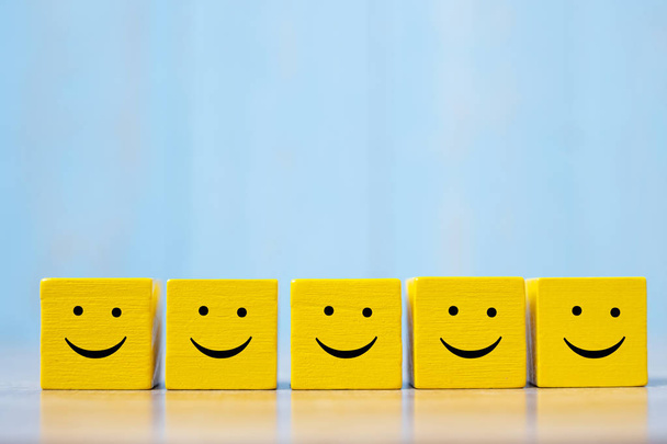 smiley face on yellow wood cube. Service rating, ranking, custom - Valokuva, kuva