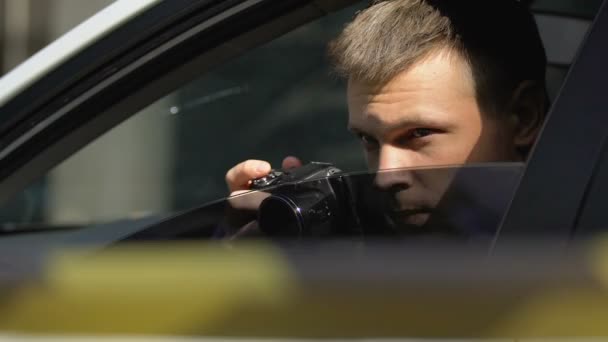 Journalist taking photo over barricade tape hiding in car, crime investigation - 映像、動画