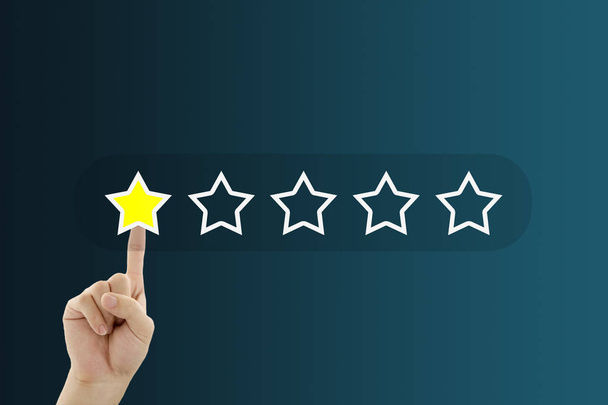 Klant feedback concept: hand drukken één gele ster voor het geven van de beste service ranking. - Foto, afbeelding