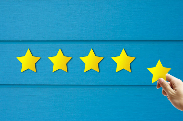 Koncepcja opinii klientów: ręczne trzymanie i nadanie żółtej gwiazdy najlepszego rankingu usług. - Zdjęcie, obraz