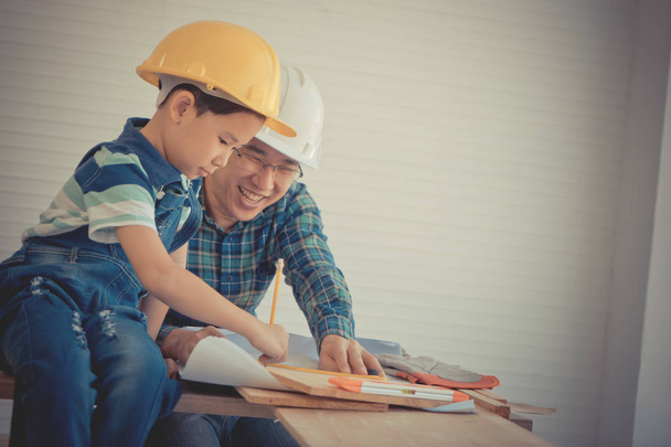 Little Boy está aprendiendo a ser constructor de su padre artesano.  - Foto, Imagen