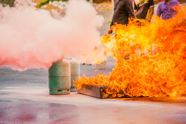 ein Feuerwehrmann in Schutzkleidung, Helm und Atemschutzgerät, wobei bei der Brandschutzübung Gas aus dem Hydranten entweicht. - Foto, Bild