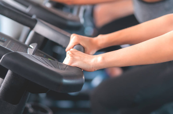 Woman hand gripping on Fitness Cycling Machine in Fitness gym - Foto, Imagen