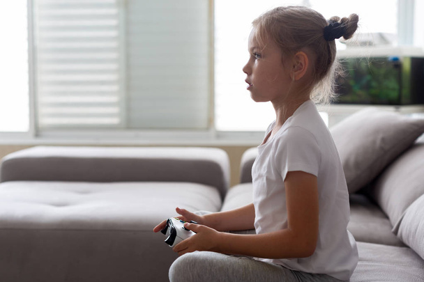 Caucasian girl with strong tense expression playing video games holding game controller - Photo, Image