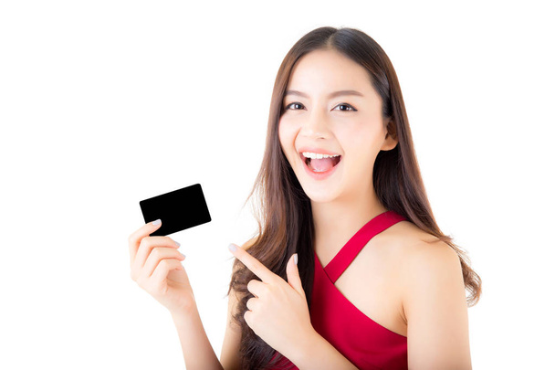 Asiática joven con vestido rojo sosteniendo una tarjeta de crédito pensando
  - Foto, imagen