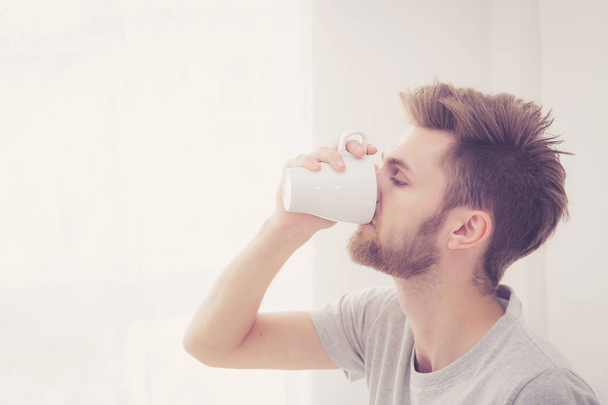 american man with cup of coffee in bedroom with morning. - Photo, Image