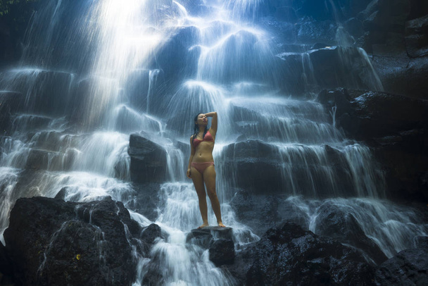 природный портрет молодой красивой и счастливой азиатки в бикини, наслаждающейся природой на тропическом райском водопаде с волшебным чувством в душе вдохновения
 - Фото, изображение