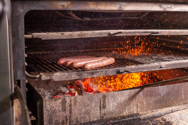 food, craft and delicious concept - cooking sausages on a grill - Photo, Image