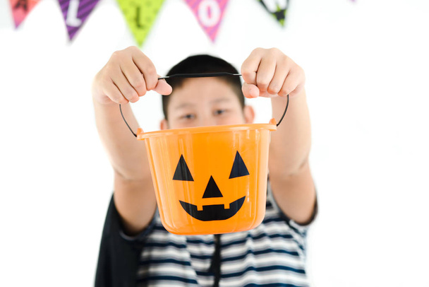 Asian boy with orange pumpkin bucket, halloween concept. - 写真・画像