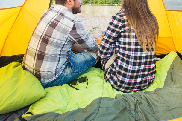 люди, летний туризм и концепция природы - молодая пара отдыхает в палатке кемпинга, вид изнутри
 - Фото, изображение
