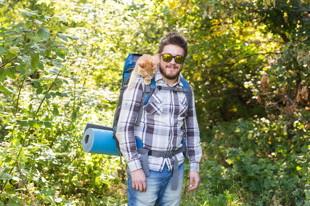 Adventures, summer tourism and nature concept - tourist arriving to a camping with his cat - Фото, зображення