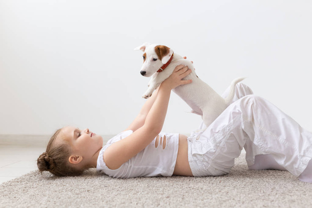 Animaux et concept animal - Enfant fille jouer avec chiot Jack Russell Terrier
 - Photo, image