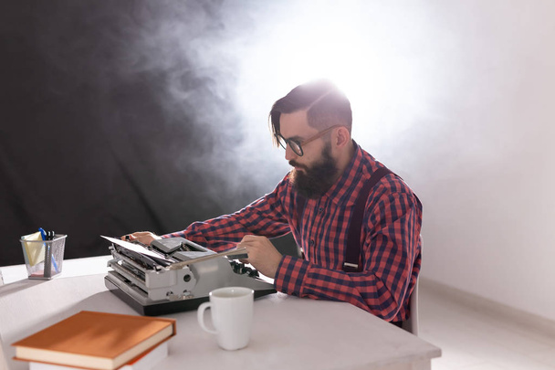 mensen, schrijver en hipster concept - jonge stijlvolle schrijver en werkt op typemachine - Foto, afbeelding