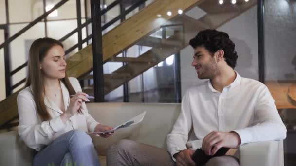 Jungunternehmer diskutieren auf dem Sofa über den Jahresabschluss des Unternehmens - Filmmaterial, Video