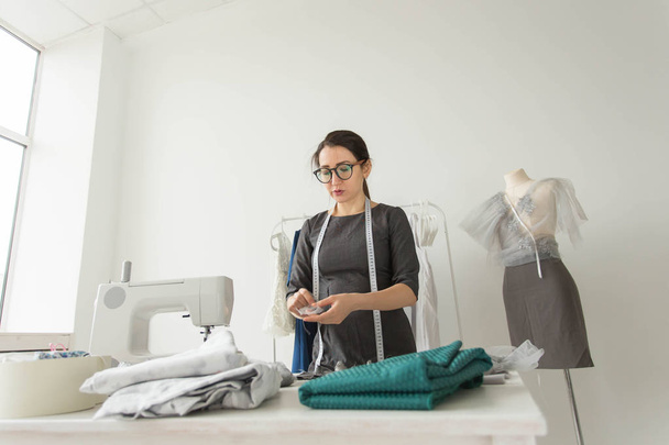 Dressmaker, fashion designer, tailor and people concept - Portrait of a seamstress at work in her own studio - Foto, Imagen