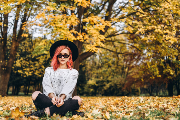 Pretty girl with red hair and hat relaxing in the park, autumn t - Foto, Imagen