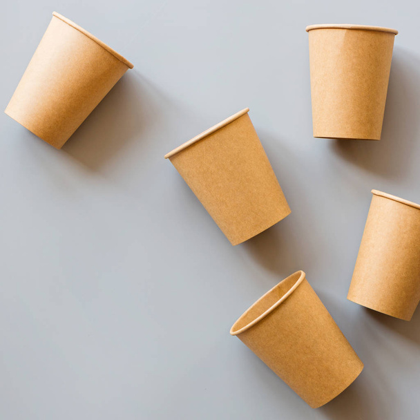 eco natural paper coffee cups flat lay on gray background. sustainable lifestyle concept. zero waste, plastic free items. stop plastic pollution. Top view, overhead, mockup, template - Фото, изображение